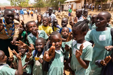 Children in Sudan making the Scout symbol