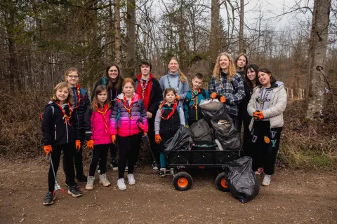 Slovenian Scouts smile holding trash bags.