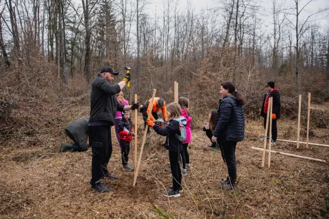 Adults and children planting trees.