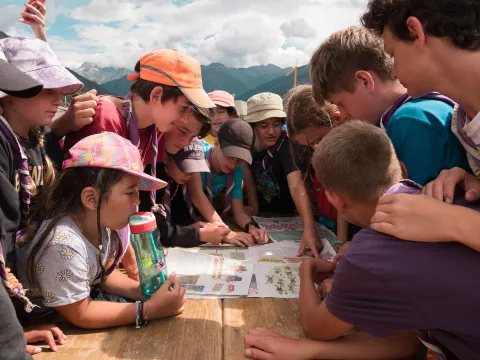 Scouts at MOVA 2022 looking at drawings on a flipchart.