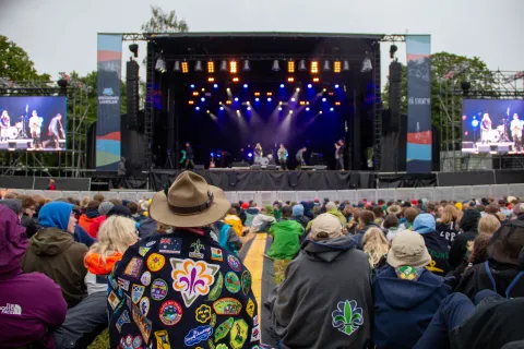 Participants from Landsleir sit in front of a big and colourful stage.
