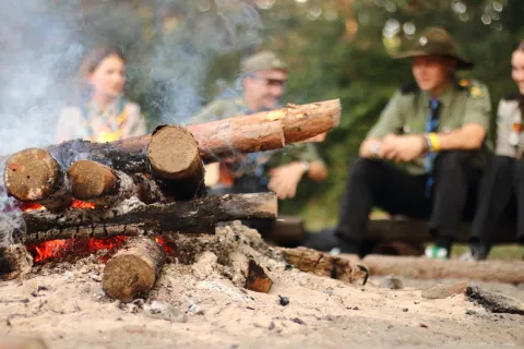 Four Scouts talk around a campfire.