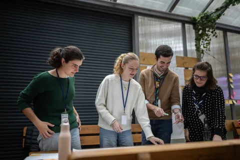 Young people standing in front of a table and placing sticky notes.