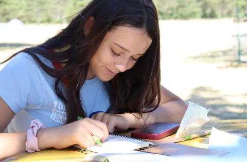 Ana is writing on a notebook.
