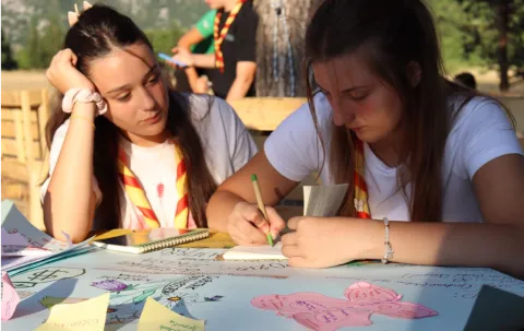 Two participants of the training write notes.