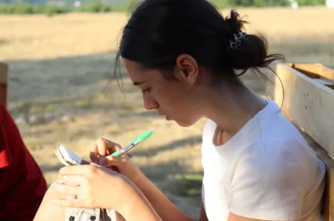 Bojana writes on a piece of paper.