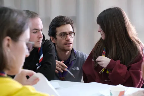 Scouts having a conversation around a table.