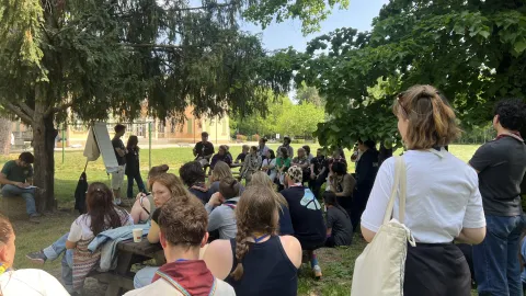 Young people sit outdoors during one of the sessions of the Agora 2026.