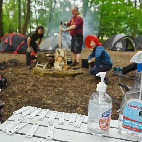 A Scout group and tents can be seen in the background with negative Covid-19 rapid tests and sanitiser in the forefront