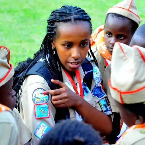 Scout shows her badge to younger Scout