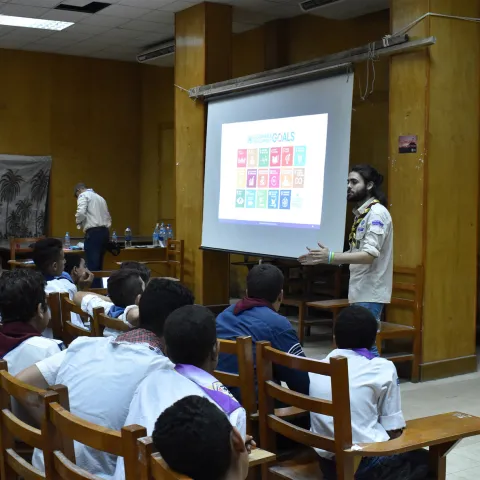 a leader explaining the sdgs to a group of scouts