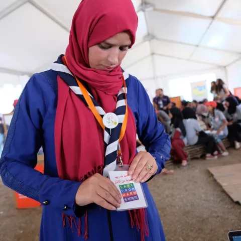 A Scout Leader adjusts her Safe From Harm badge