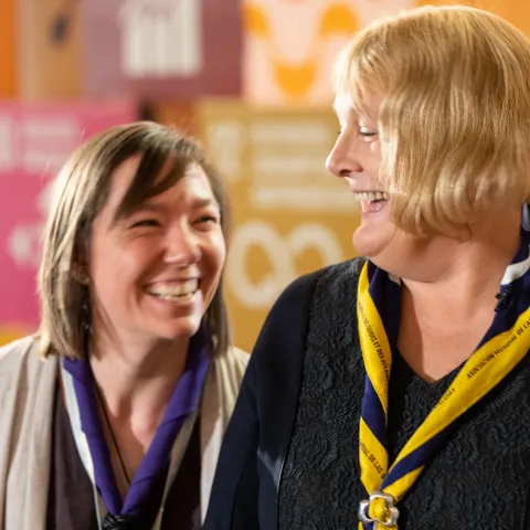 Two female Scouts smile at the World Scout Education Congress