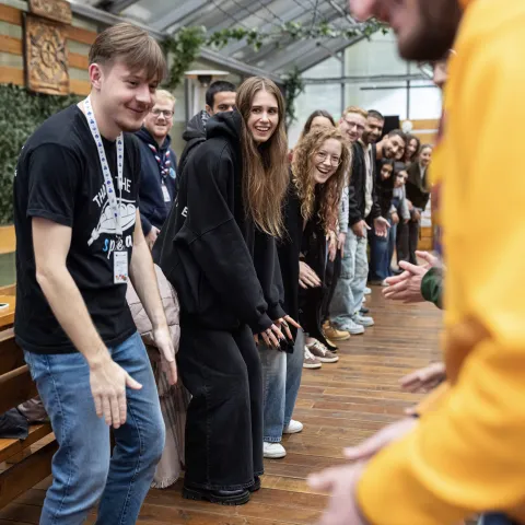 Young people stand in line making the same movements.