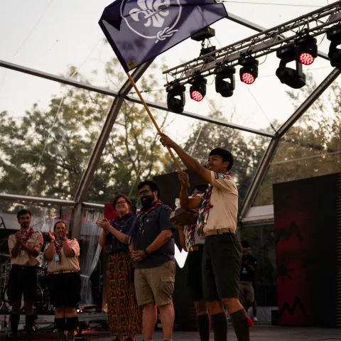 A Rover scout holding the Scout flag